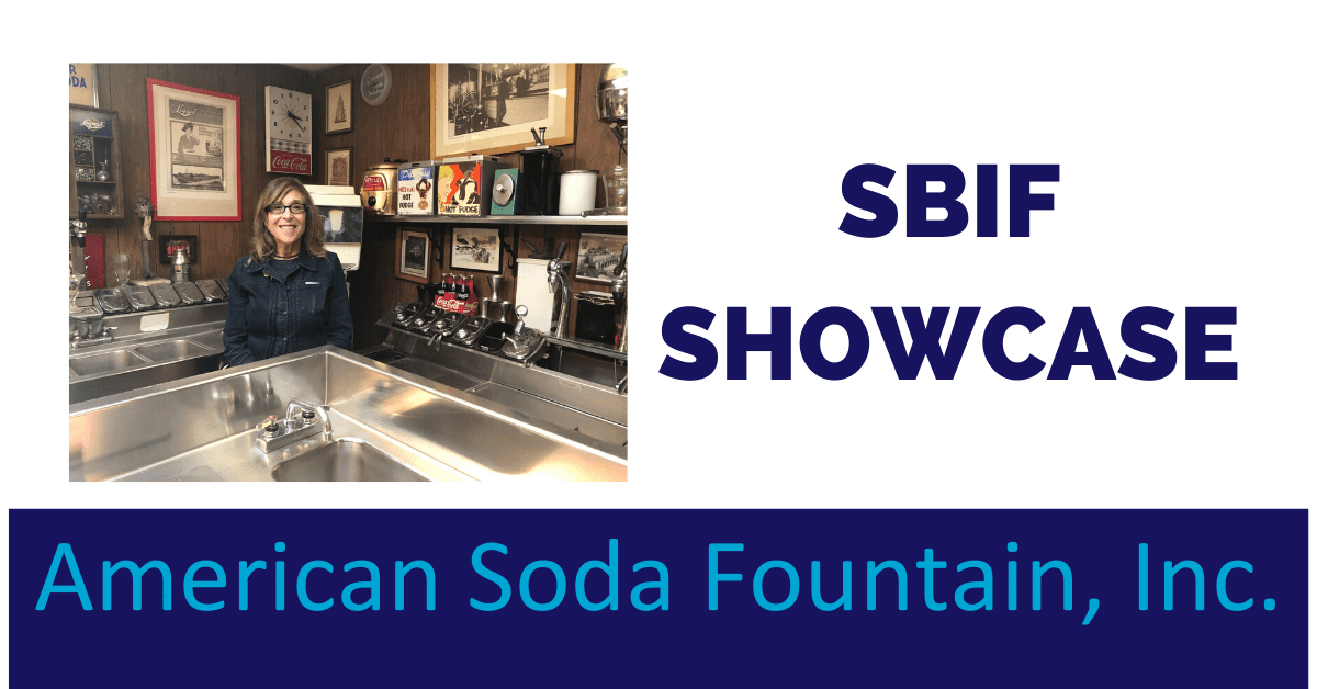 A man standing in front of an american soda fountain.