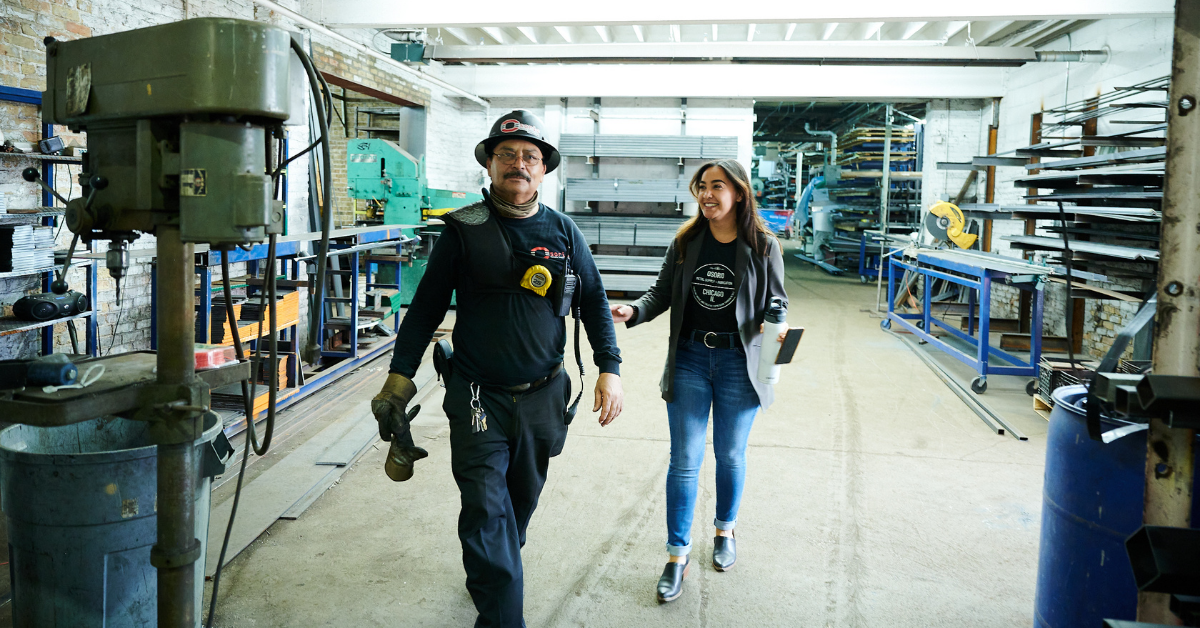 A man and woman walking in a warehouse.