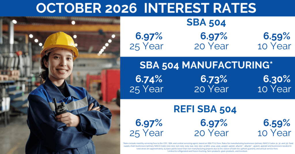 Woman in hard hat smiling in industrial setting.